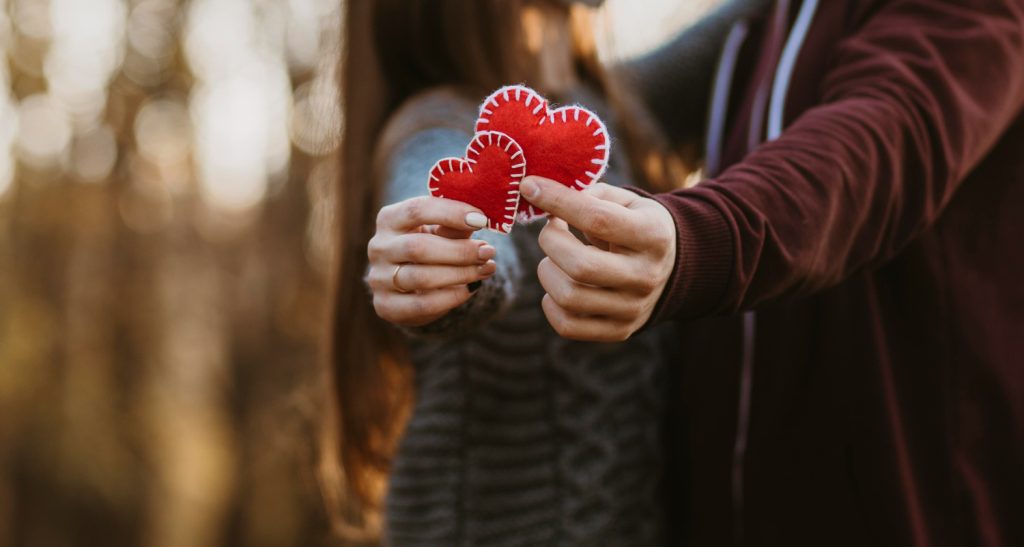 Couple holding small fabric hearts in their hands